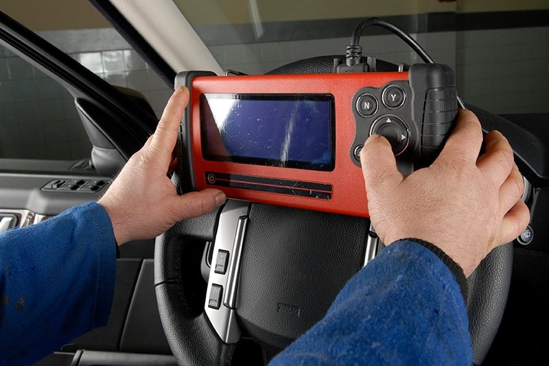 A diagnostic scan tool connected to a vehicle
