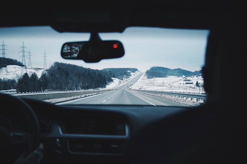 A snowy Colorado highway seen from the driver's seat
