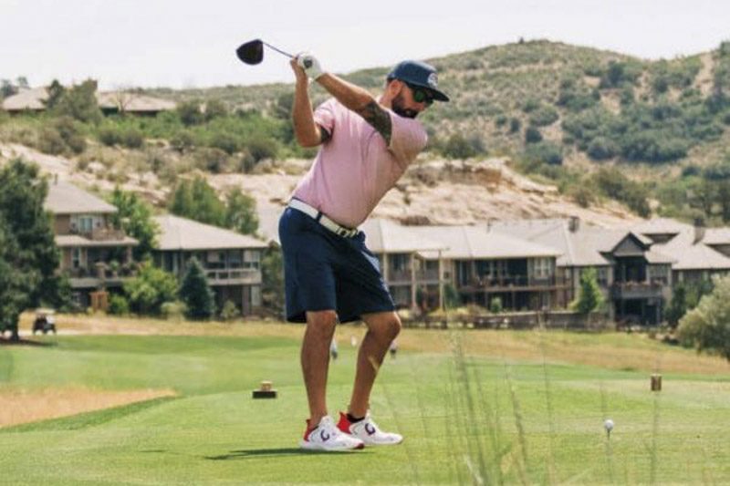 TJ Cobbett teeing off on a golf course below the hogback near Solterra